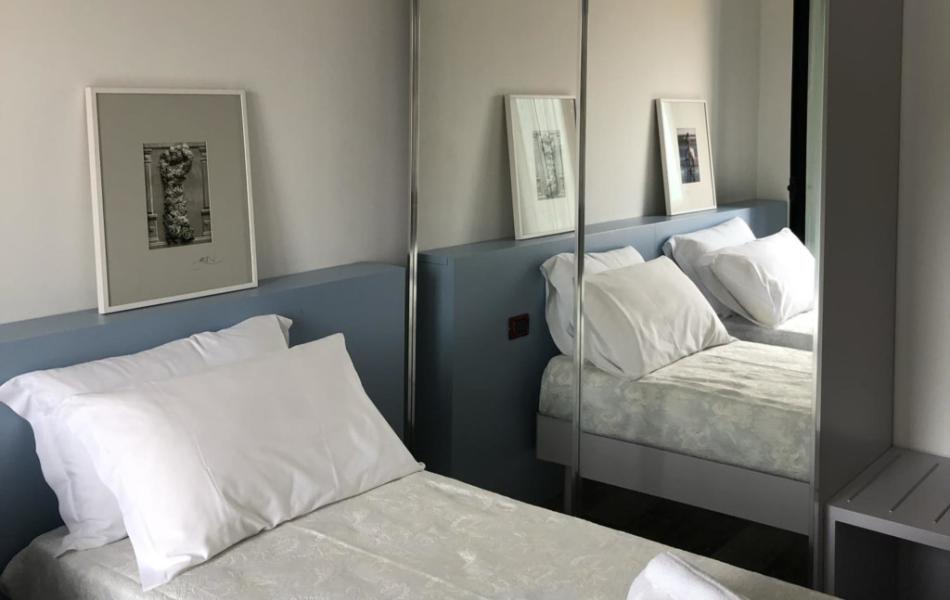 Camera da letto moderna con letto singolo e specchio a parete.